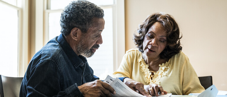 Senior couple paying bills at home